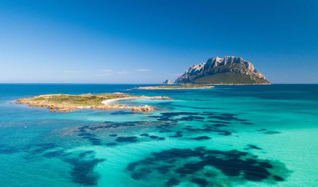Panoramic view of Costa Smeralda in Sardinia with turquoise waters and pristine beaches.